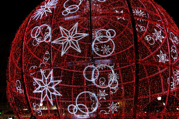 beautiful big glowing red bauble Christmas decoration in Alicante, Spain at night background closeup