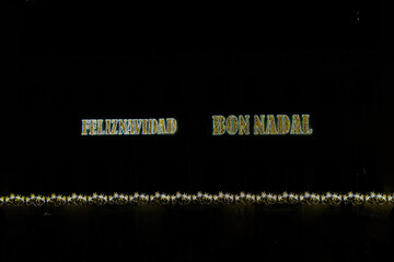  golden shiny neon inscription merry christmas on a black background in Spanish and Catalan, Valencian