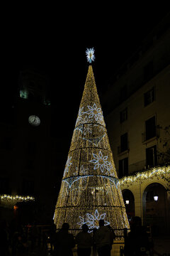 golden glowing christmas tree decoration on black background Alicante Spain in front of the town hall