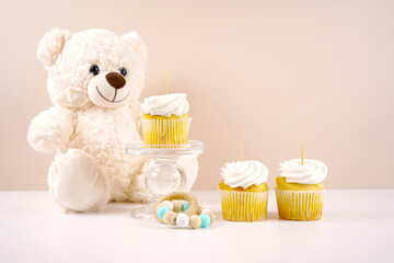 Vanilla cupcake topper mockup. Baby shower 1st birthday christening gender neutral party theme. Styled setting with white teddy bear against a beige and white background. Negative copy space.