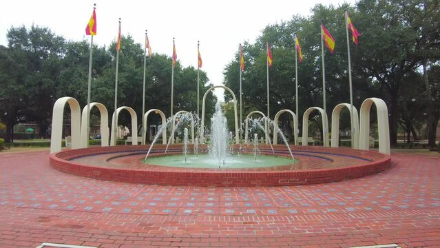 Beautiful view of a fountain in the Spanish Plaza Park with green trees