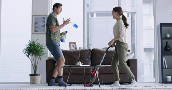 Teamwork, dance and couple with help cleaning, vacuuming and disinfection of living room carpet. Playful, funny and man and woman dancing to clean the lounge of their apartment for spring cleaning