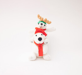Two happy plush toy polar bears with Santa Claus hat, scarf and reindeer antlers.