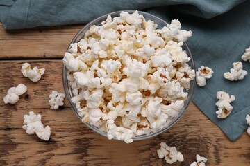 Tasty popcorn on wooden table, flat lay
