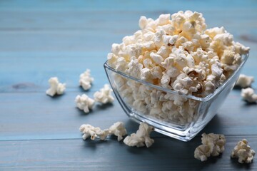Tasty popcorn on light blue wooden table