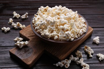 Tasty popcorn on black wooden table, closeup