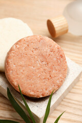 Dish with solid shampoo bars on wooden table, closeup