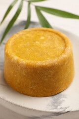 Dish with solid shampoo bar on table, closeup