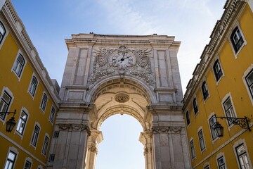 Low-angle shot of the Rua Augusta Arch in Lisbon against a blue sky