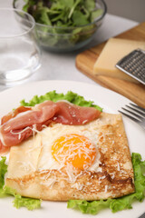 Delicious crepe with egg on table, closeup. Breton galette