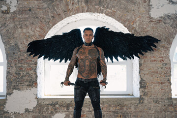  angel man with black wings, stand posing at camera. man fall from heaven, angel with muscular body gained freedom.  tattooed hot man. tattooed black angel. dark angel in leather