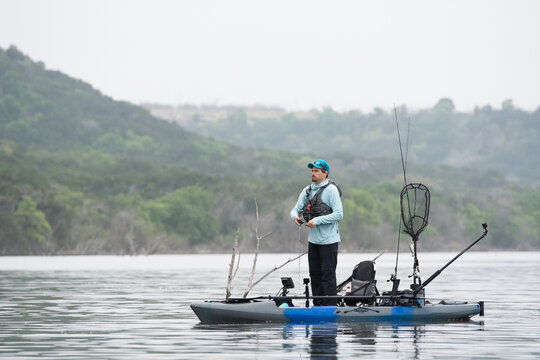 Fishing for bass while standing on kayak on a Texas lake