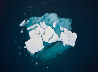 Iceberg in green calm seawater