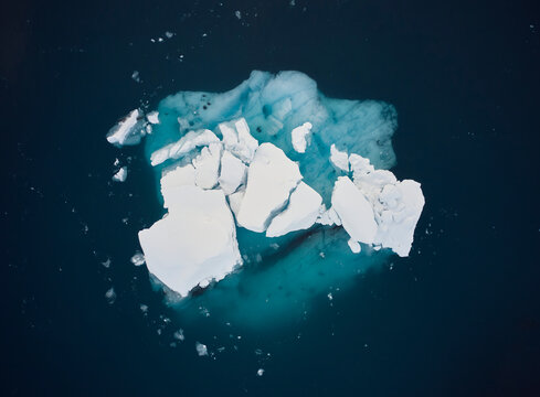 Iceberg in green calm seawater