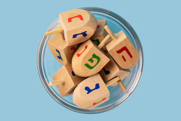 Jewish holiday Hanukkah concept. Wooden dreidel (spinning top) on blue background.