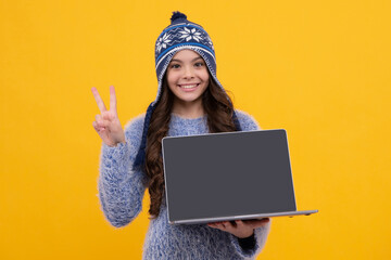 School girl teenager child student in warn hat hold laptop, isolated background. Learning and knowledge education concept. Happy face, positive and smiling emotions of teenager girl.