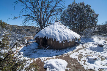 Mud hut survival shelter covered in snow