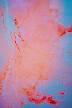 Psychedelic watercolor stains on wall in shades of blue, red, orange, and purple.