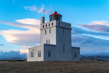 Fototapeta na wymiar Scenic view of the historic Dyrhólaeyjarviti lighthouse on Dyrhólaey peninsula under a dramatic cloudy sky, Iceland, near Vík í Mýrdal and Route 1 / Ring Road