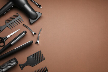 Flat lay composition of professional hairdresser tools on brown background, space for text