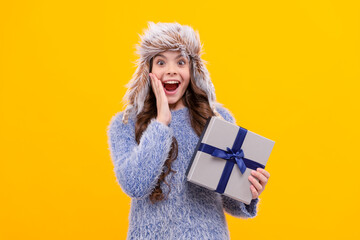 shocked teen girl wear earflap hat with purchase ox on yellow background, holiday