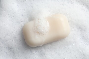 Soap and fluffy foam on white background, top view