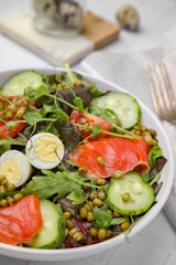 Bowl of salad with mung beans on white tiled table, closeup