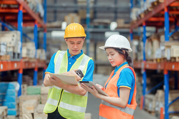 Asian engineer in helmets order and checking goods and supplies on shelves with goods background in warehouse.logistic and business export ,Warehouse worker checking packages on shelf in a large store