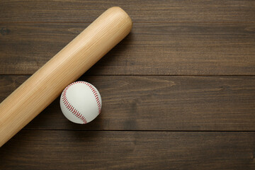 Baseball bat and ball on wooden table, top view with space for text. Sports equipment