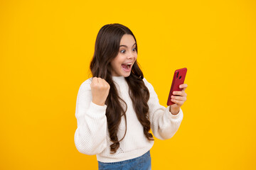 Excited teenager girl child using mobile phone, chatting on web. Mobile app for smartphone. Children lifestyle concept.