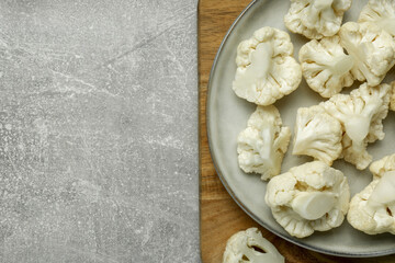 Cut fresh raw cauliflowers on grey table, top view. Space for text