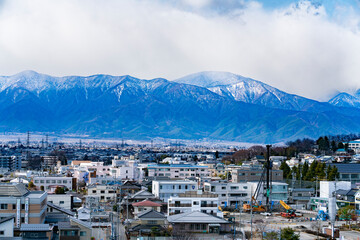 雲の多い日に撮影した、山脈と街並み