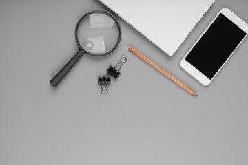 Top view accessories office concept. Mobile phone, notepaper, pen, Magnifying glass on office desk.