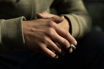 Obraz premium Hand in detail. Cigarette sandwiched between packs.