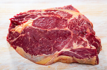 Close up of uncooked beef chop on wooden background