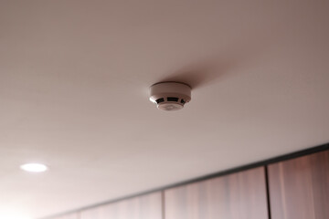 Fire system indoors. White smoke detector issue a signal to a fire alarm control panel as part of a...
