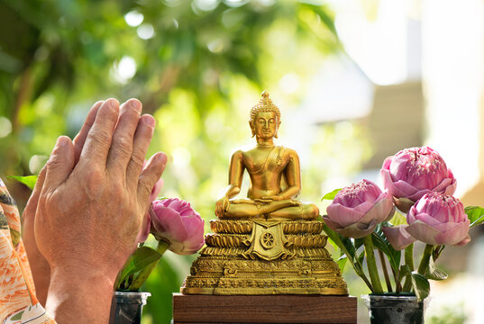 Men raise their hands to pay homage to Buddha images for good luck on Thai New Year's Day.