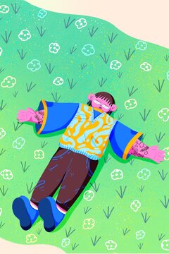 Young person with tattoos and sunglasses enjoys a day lying in the park with flowers