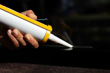 The craftsman's hand uses a silicone adhesive to connect the glass to the glass to stick together.