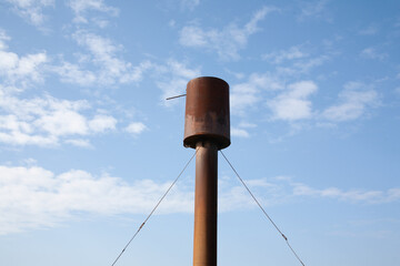 Old water tower against the blue sky. Water reserves. Rusted water tower