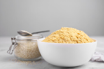 Sesame flour in ceramic bowl on white marble table