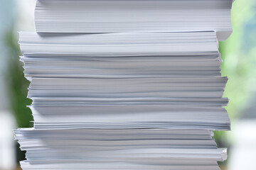 Stack of paper sheets against blurred background, closeup