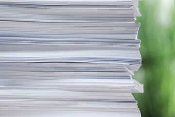 Stack of paper sheets against blurred background, closeup