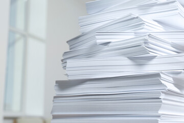 Stack of paper sheets against blurred background, closeup. Space for text