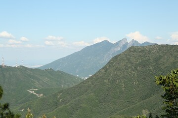 Picturesque view of mountains and trees under cloudy sky