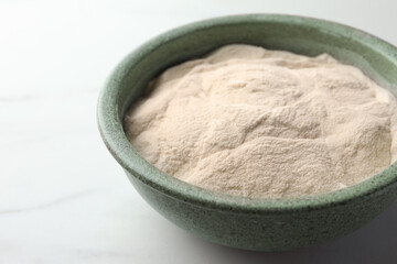 Fototapeta na wymiar Bowl of agar-agar powder on white table, closeup