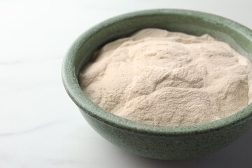 Bowl of agar-agar powder on white table, closeup