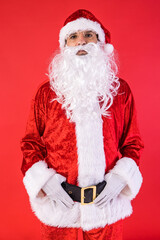 Portrait of man dressed as Santa Claus, posing to camera, on red background. Christmas, celebration, gifts, consumerism and happiness concept.