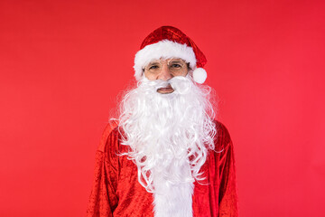 Portrait of a man dressed as Santa Claus, on red background. Christmas, celebration, gifts, consumerism and happiness concept.
