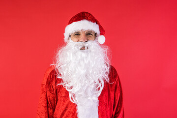 Portrait of a man dressed as Santa Claus, on red background. Christmas, celebration, gifts, consumerism and happiness concept.